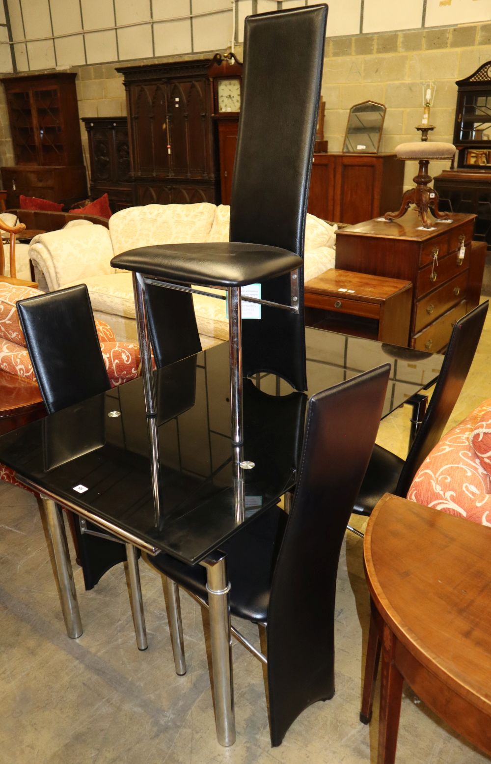 A modern chrome and black glass extending dining table with six matching dining chairs